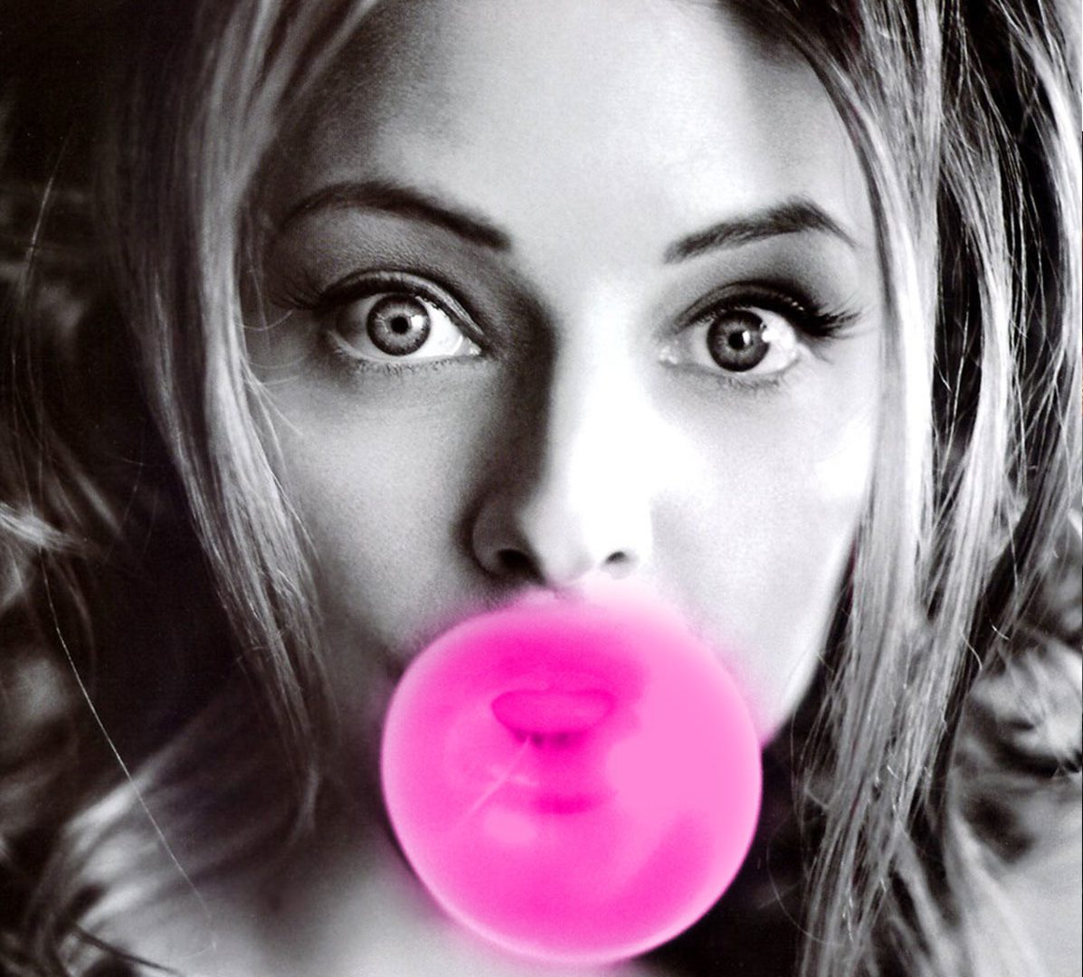 A woman with pink bubble gum in her mouth.