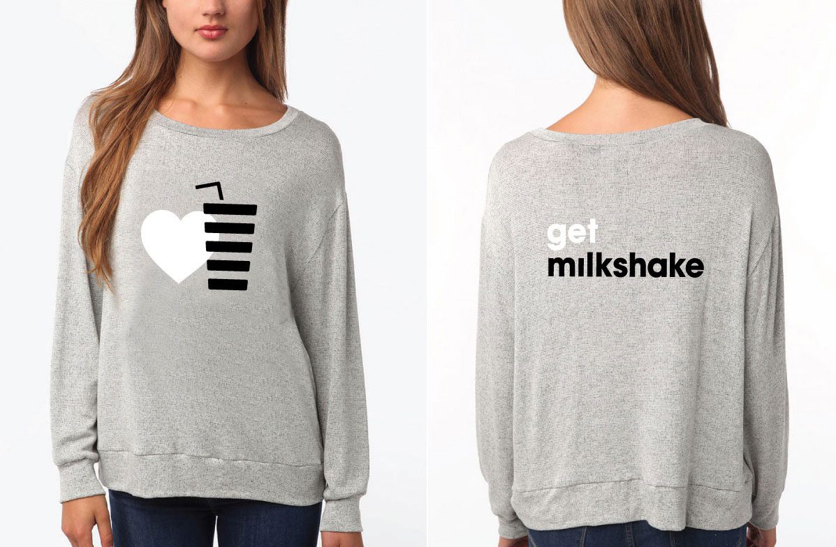A woman wearing a sweater with an image of a milkshake.